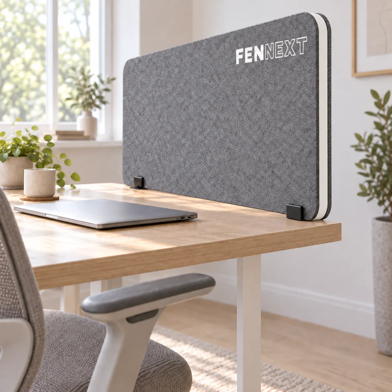 Desk Divider Icon Silbergrau mit ausgeschnittenem FENNEXT-Schriftzug am Arbeitsplatz